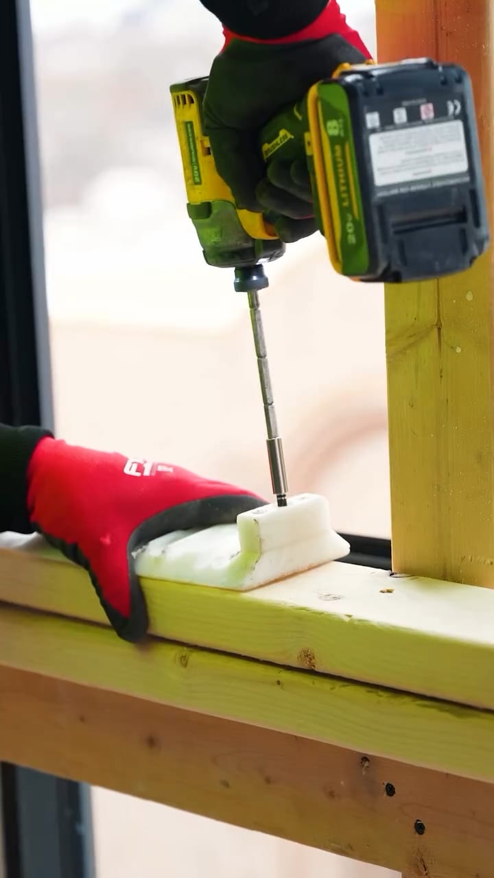 Close-up of crew member fastening drywall clips