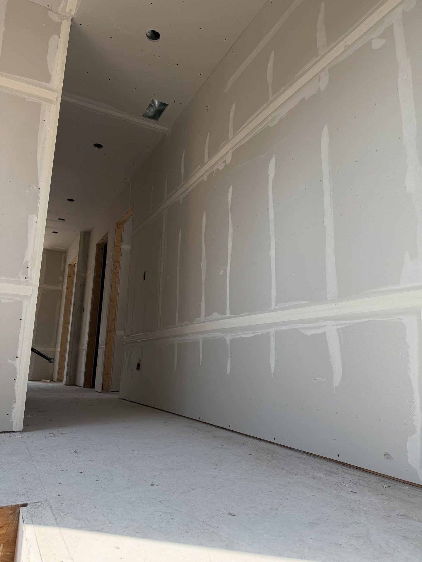 Hallway with freshly hung drywall panels