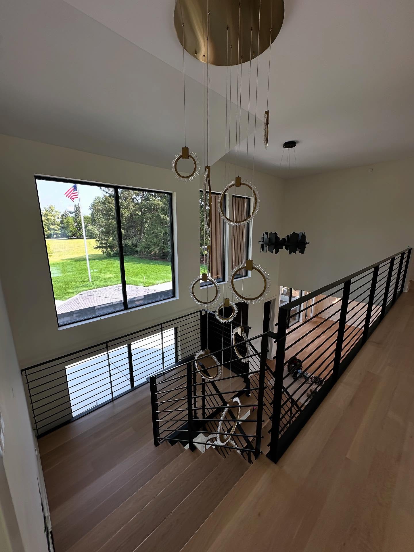 Two-story foyer with modern black railing and statement chandelier