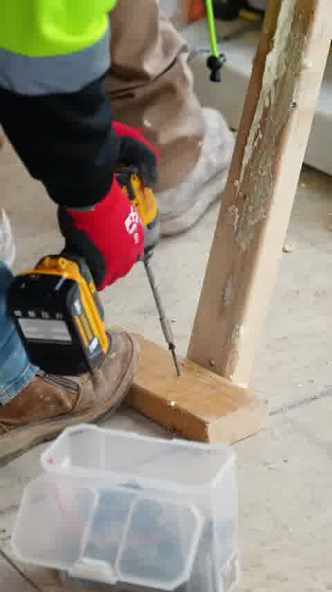 Worker drilling framing with a DeWalt impact driver