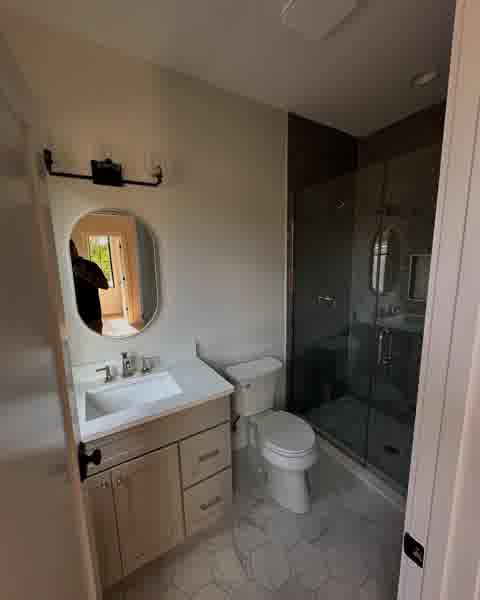 Bathroom with oval mirror, subway tile shower and hex marble floor, Clarendon Hills