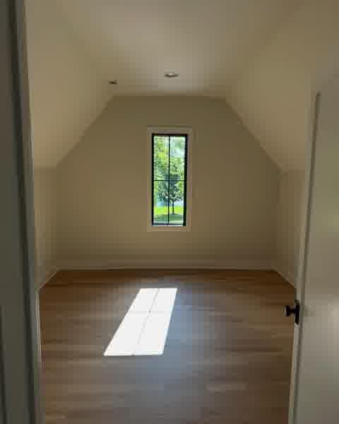 Vaulted attic bedroom with black-frame window and clean drywall finish, Clarendon Hills