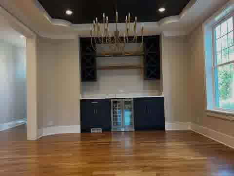 Wet bar with navy cabinets, wine cooler, gold chandelier and black tray ceiling, Elmhurst
