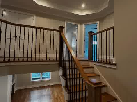 Upper staircase landing with iron balusters, oak railing and tray ceiling, Elmhurst