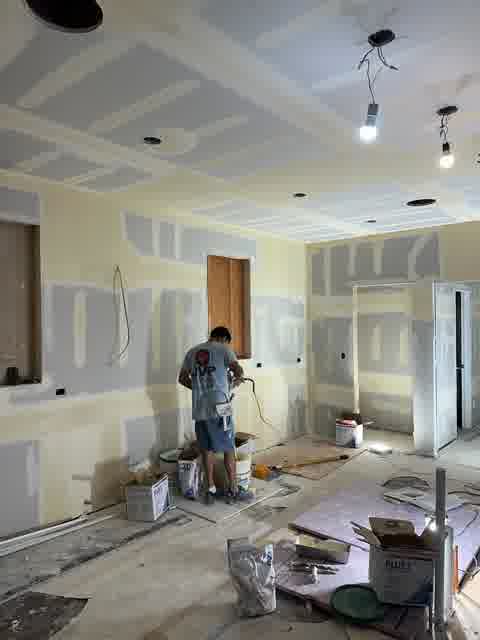 JVP crew member in branded shirt spraying large room with professional spray equipment, Glenview