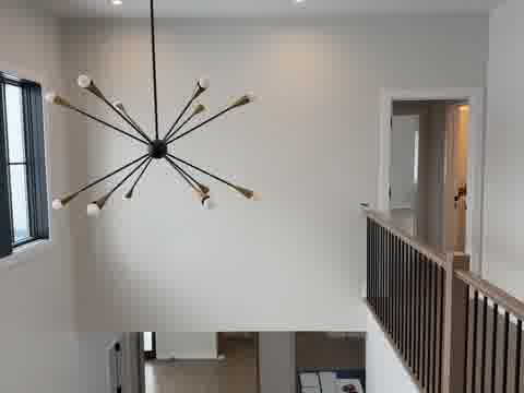 Two-story foyer with massive clean white wall, chandelier and hardwood floors viewed from below, Northbrook