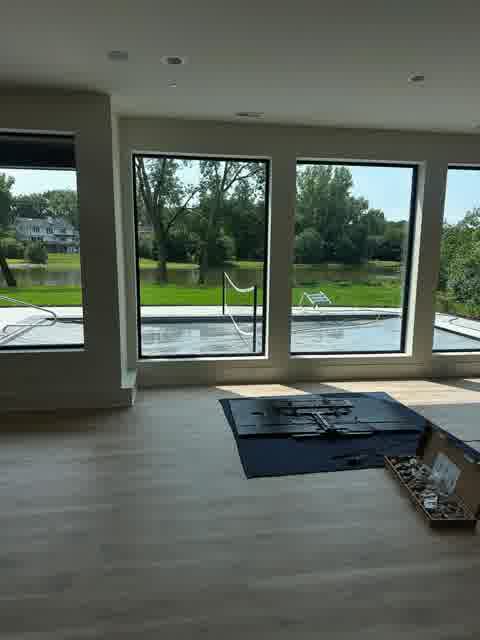 Open living room with floor-to-ceiling windows overlooking lake and pool, clean drywall ceiling, Oak Brook