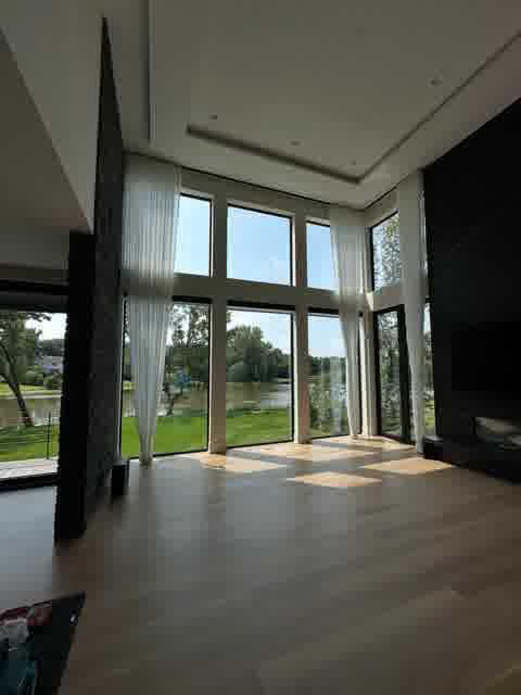 Double-height great room with floor-to-ceiling windows, lake view and sheer curtains, Oak Brook