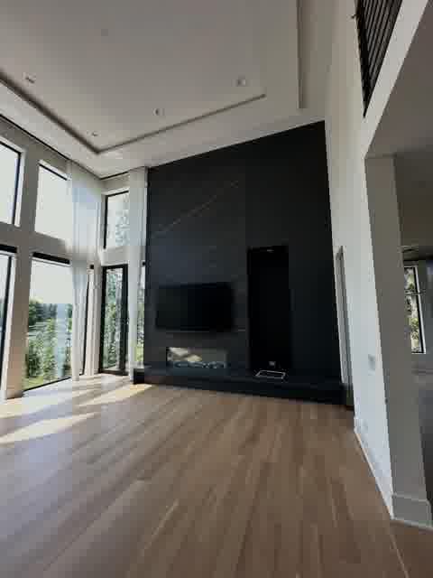 Black marble fireplace wall with linear fireplace and TV in double-height room, Oak Brook