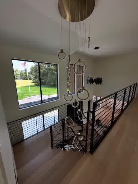 Second floor landing with cascading ring chandelier and black metal railing, Oak Brook