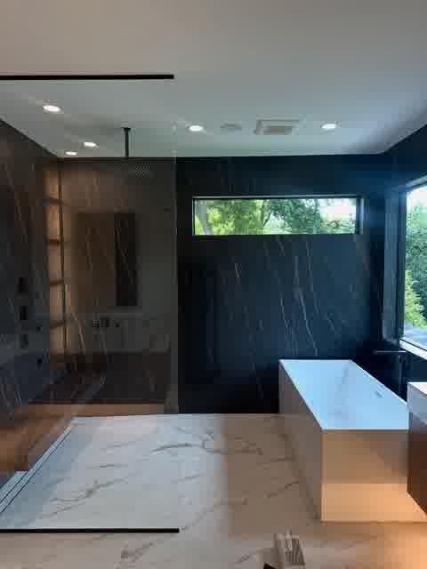 Dark veined stone master bath with freestanding tub, rain shower and tree views, Oak Brook